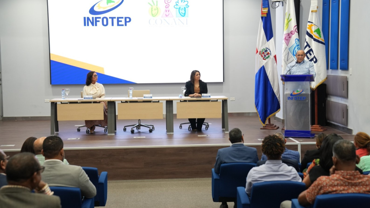 Rafael Santos Badía se dirige a los presentes. En el escenario Luisa Ovando y Alexandra Santelises presidenta ejecutiva y directora ejecutiva de CONANI
